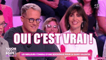 a man and a woman are sitting in front of a screen that says oui c'est vrai