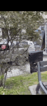 a black mailbox is sitting on a bench in front of a tree .