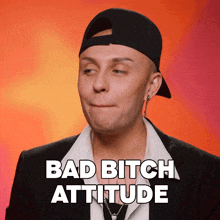 a man wearing a baseball cap and a suit has bad bitch attitude written on his face