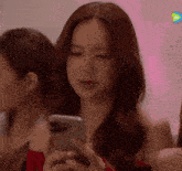 a woman in a red dress looks at her phone