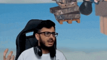 a man wearing glasses and headphones is sitting in a chair with a stack of boxes hanging from the ceiling .