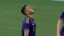 a soccer player in a purple jersey with the number 1 on it celebrates a goal