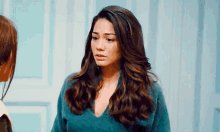 a woman with long hair is standing next to another woman in a room .