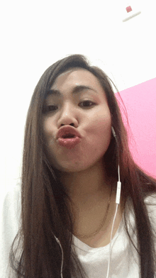 a woman wearing earphones makes a funny face