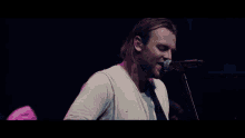 a man singing into a microphone with his eyes closed