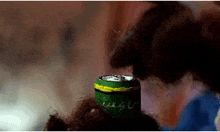 a green and yellow can with arabic writing on the cap