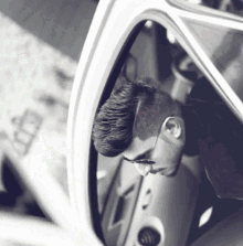 a man is sitting in a car with the door open