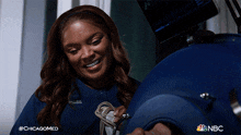 a woman is smiling in front of a machine that says nbc