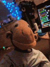 a stuffed monkey in front of a computer monitor