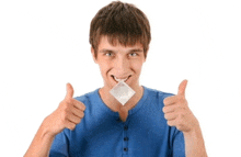 a young man is holding a condom in his mouth and giving a thumbs up