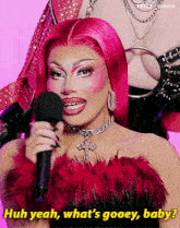 a woman with pink hair is holding a microphone and saying huh yeah what 's gooey baby .