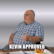 a man in a plaid shirt is giving a thumbs up and the caption kevin approved