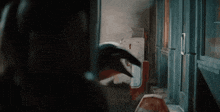 a person standing in a dark room with a hammer