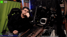 a man sitting in front of a computer with the number 45 on the top right