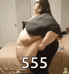 a very fat woman is standing on a bed with her arms outstretched .