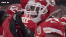 a football player wearing a helmet with the letter t on the bottom