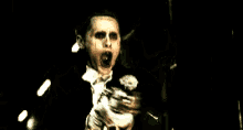 a man is laying in a dark room with a glowing light coming out of his mouth .