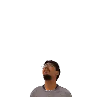 a man with glasses looks up at a green cross on his head