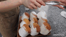 a person is dusting cupcakes with powdered sugar and the words made in animotica are visible