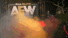 a man in a suit stands in front of a sign that says " all elite aew "