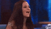 an older woman is sitting in front of a crowd on a television show .