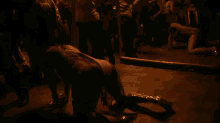 a woman is crawling on the floor in a crowded room