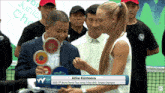 a woman named elina korneeva is being presented with a trophy