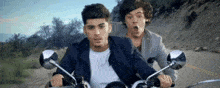 two men are riding motorcycles down a road and one is making a funny face .