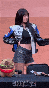 a woman wearing a suzuki jacket is holding a pan