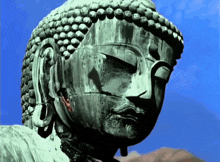 a statue of a buddha with a blue sky behind it