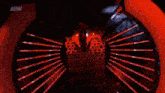a woman is dancing on a stage in a dark room with red lights .