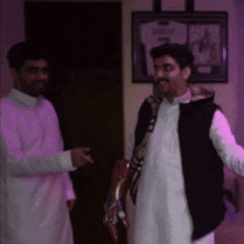 a man in a black vest is standing next to a man in a white robe
