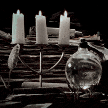 a candle holder with three lit candles and a bottle of liquid