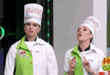 two women wearing chef hats standing next to each other .