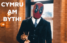 a man wearing a deadpool mask is holding an award