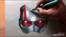 a person is drawing an ant man helmet with a green pencil