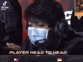 a man wearing a mask and headphones with the words player head to head on the bottom