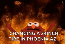 elmo is standing in front of a fire and says `` changing a 24 inch tire in phoenix az ''