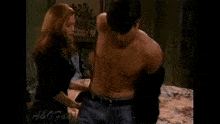 a shirtless man is standing next to a woman on a bed
