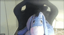 a stuffed eeyore is sitting on a chair in a video call
