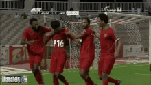 a group of soccer players celebrate a goal with the number 16 on their shirts