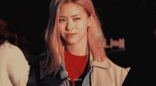a girl with pink hair is wearing a denim jacket