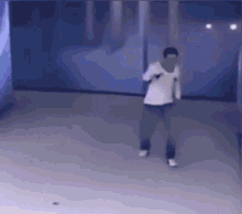 a man in a white shirt is dancing in a room .