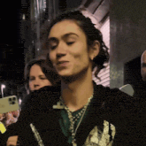 a woman in a black jacket has a necklace around her neck that says ' i love you '