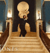 a man is standing on a set of stairs in front of a statue with the words ring jones on the bottom