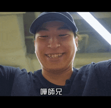 a man wearing a hat and a shirt with chinese writing on the bottom