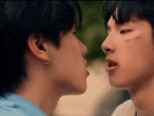 a man with a scar on his face kisses another man on the forehead