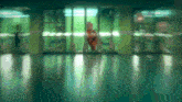 a blurred image of a person standing in a hallway with the letter o on the door