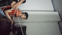 a man in a red shirt is laying on the floor with headphones