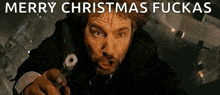 a man is pointing a gun at the camera with the words `` merry christmas fuckas '' written above him .